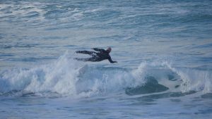 Man in the sea, big wave, falling off surf board