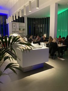 Image shows a large cafe area at night with green illimuniated window