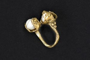 Brass ring with two pearls.