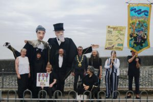 Image shows Shalla Arts group at Newlyn Art Gallery with Passmore edwards pupets and banners