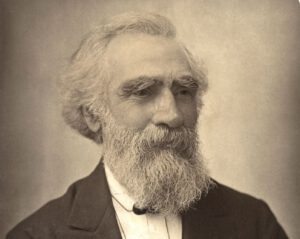 Black and white, sepai toned photo of beared man, known to be John Passmore Edwards
