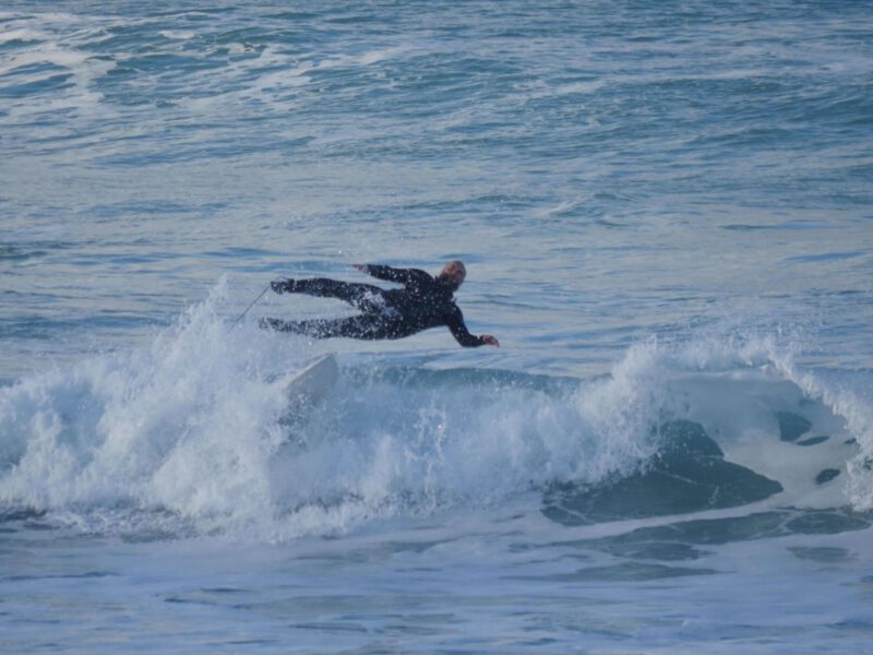Man in the sea, big wave, falling off surf board