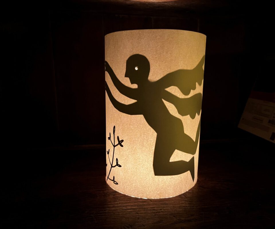 Image shows a lantern lit from inside with a image in shadow