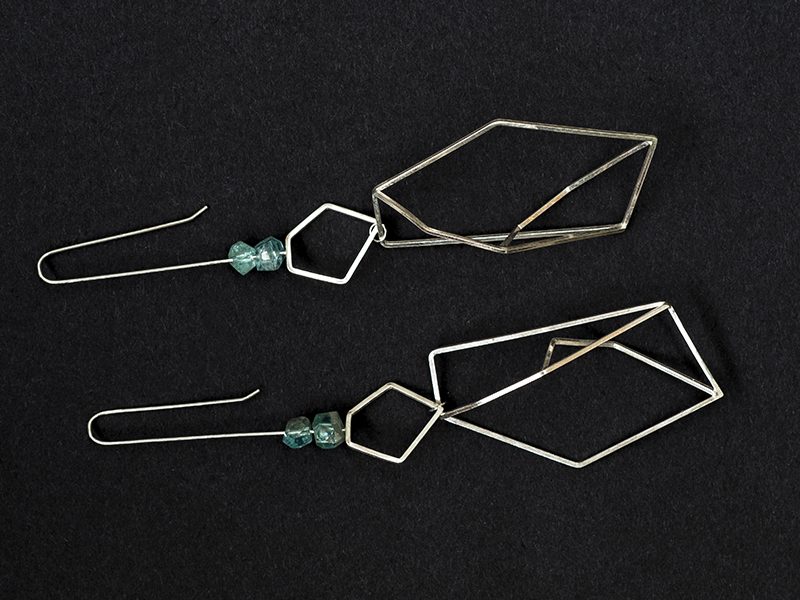 Silver dangly geometric earrings with apatite crystals on black background