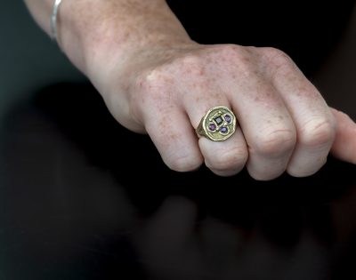 Hand modelling Dwynwen Ring with Ruby and Tourmaline on black background