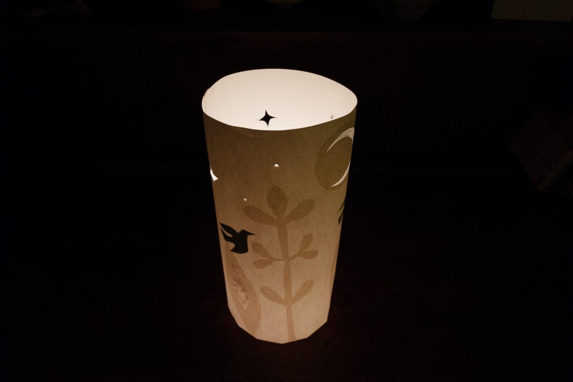 Image shows a lantern lit from inside with a image in shadow