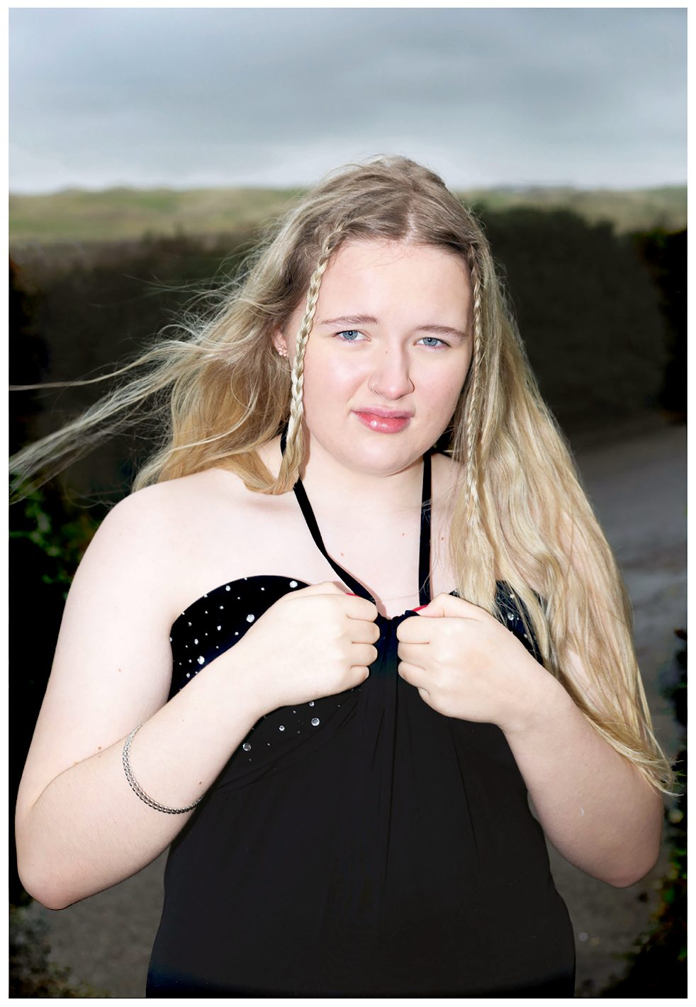 Image shows a photo by Fran Rowse of a young white woman with long blond hair wearing a black halterneck dress