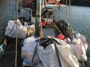 Image shows large bags of marine rubbish on the deck of a boat