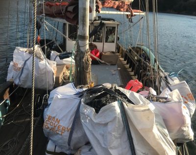 Image shows large bags of marine rubbish on the deck of a boat