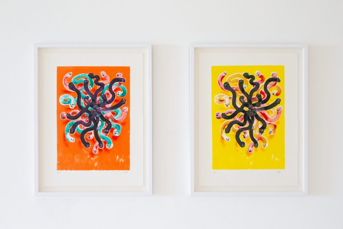 two framed red and yellow worm monster prints